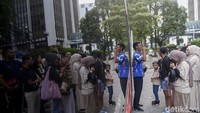 Pemandu wisata memberikan pengenalan dan arahan kepada wisatawan sebelum menaiki bus.