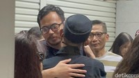 Surya terlihat tegar dan tersenyum, meski air matanya tetap menetes dalam pelukan keluarga. Foto: Pingkan/detikHOT