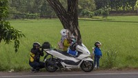 Pemotor beristirahat sekaligus memperbaiki sepeda motornya di jalur pantura Jatibarang, Indramayu, Jawa Barat, Sabtu (5/4/2025).