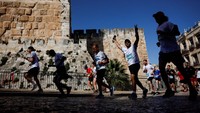 Orang-orang berlari selama Jerusalem Marathon di Yerusalem, 4 April 2025.