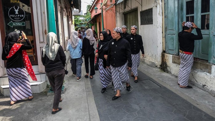 Wisatawan berjalan melewati koridor Kampung Batik Kauman Solo Jawa Tengah, Sabtu (5/4/2025). Menurut Ketua Paguyuban Kampung Wisata Batik Kauman Gunawan Setiawan jumlah pengunjung di lokasi wisata itu mencapai 1.000-2.000 orang per hari pada momen libur Lebaran yang turut mendongkrak penjualan UMKM batik hingga 80 persen dibanding hari biasa. ANTARA FOTO/Maulana Surya/tom. *** Local Caption ***