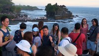Wisatawan menikmati suasana saat libur Lebaran di Daya Tarik Wisata (DTW) Tanah Lot, Tabanan, Bali, Sabtu (5/4/2025).