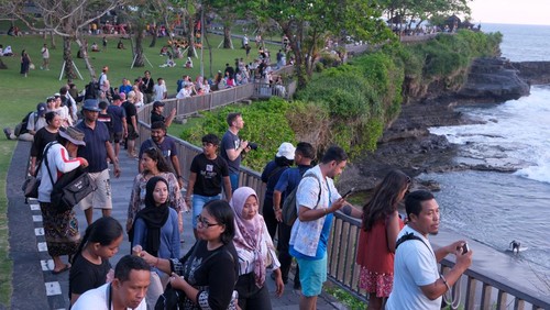 Wisatawan menikmati suasana saat libur Lebaran di Daya Tarik Wisata (DTW) Tanah Lot, Tabanan, Bali, Sabtu (5/4/2025). Pengelola objek wisata mencatat pada masa libur Lebaran 31 Maret-4 April 2025 jumlah kunjungan wisatawan ke objek wisata itu sebanyak 35.000 orang dengan persentase yakni 70 persen wisatawan dometik dan 30 persen wisatawan mancanegara. ANTARA FOTO/Nyoman Hendra Wibowo/tom.