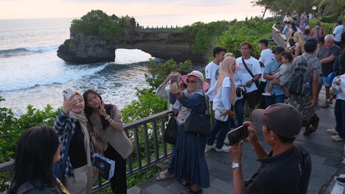 Wisatawan menikmati suasana saat libur Lebaran di Daya Tarik Wisata (DTW) Tanah Lot, Tabanan, Bali, Sabtu (5/4/2025). Pengelola objek wisata mencatat pada masa libur Lebaran 31 Maret-4 April 2025 jumlah kunjungan wisatawan ke objek wisata itu sebanyak 35.000 orang dengan persentase yakni 70 persen wisatawan dometik dan 30 persen wisatawan mancanegara. ANTARA FOTO/Nyoman Hendra Wibowo/tom.