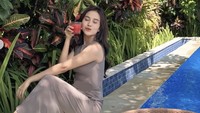 Liburan di Ubud, Bali, momen Mayang makin spesial dengan menikmati floating breakfast. Ia pun memamerkan segelas jus di tangannya. Foto: Instagram mayaang.lucyaana