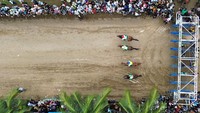 Foto udara sejumlah joki memacu kudanya dalam Pacu Kuda kelas AB terbuka 1.200 meter di Gelanggang Duku Banyak, Padang Pariaman, Sumatera Barat, Sabtu (5/4/2025).