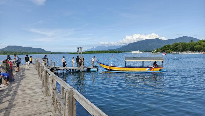 Pengunjung memasuki jukung tradisional untuk berkeliling menikmati keindahan Teluk Gilimanuk, Kecamatan Melaya, Jembrana, Sabtu (5/4/2025). (I Putu Adi Budiastrawan/detikBali)