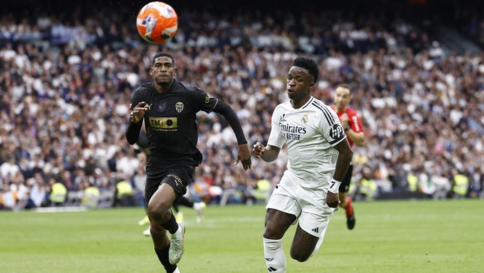Soccer Football - LaLiga - Real Madrid v Valencia - Santiago Bernabeu, Madrid, Spain - April 5, 2025 Real Madrids Vinicius Junior in action with Valencias Cristhian Mosquera REUTERS/Juan Medina