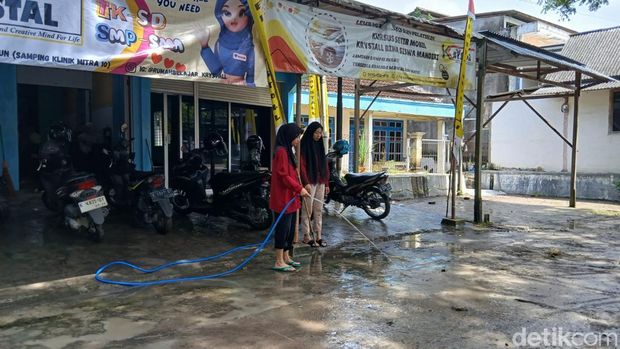 Warga di Cepu, Blora, tampak membersihkan lumpur usai banjir, Sabtu (5/4/2025).