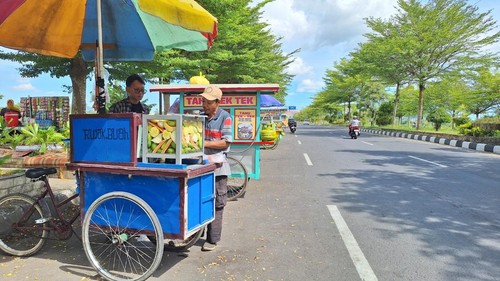 Warga tengah membeli rujak buah di Jalan Bypass Mataram, Sabtu (5/4/2025). (Nathea Citra/detikBali)