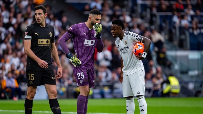 Giorgi Mamardashvili of Valencia CF speaks with Vinicius Junior of Real Madrid CF during the La Liga EA Sports 2024/25 football match between Real Madrid CF and Valencia CF at Estadio Santiago Bernabeu in Madrid, Spain, on April 5, 2025. (Photo by Alberto Gardin/NurPhoto via Getty Images)