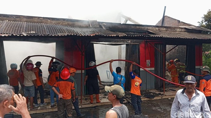 Petugas kebakaran saat memadamkan api yang membakar bangunan ruko di Desa Kandangmas Kecamatan Dawe, Kudus, Minggu (6/4/2025).