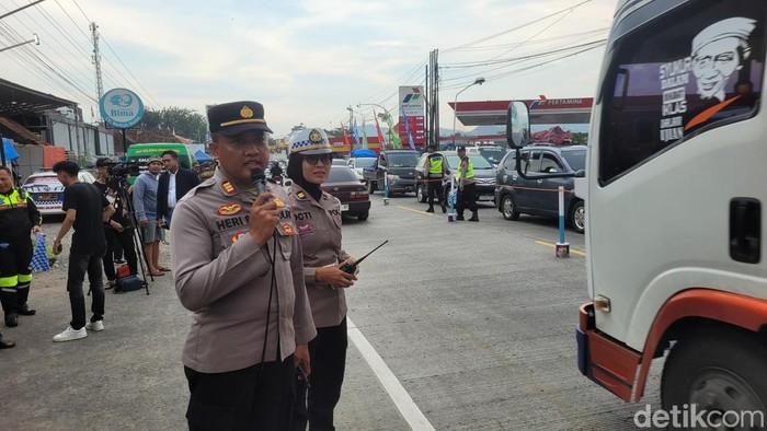 Pasangan suami istri perwira Polresta Banyumas yang bertugas bersama mengamankan arus mudik di simpang Ajibarang, Kabupaten Banyumas, Minggu (6/4/2025).