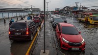 Kendaraan bermotor yang didominasi pemudik melaju perlahan menembus jalan raya pantura Demak KM Surabaya-Semarang yang terendam limpahan air laut ke daratan (rob) di Kecamatan Sayung, Kabupaten Demak, Jawa Tengah, Minggu (6/4/2025).