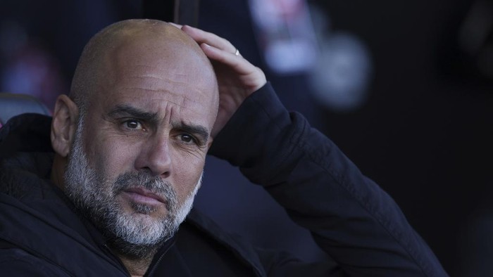 Manchester Citys head coach Pep Guardiola looks out from the bench before the English FA Cup quarterfinal soccer match between Bournemouth and Manchester City at the Vitality stadium in Bournemouth, England, Sunday, March 30, 2025. (AP Photo/Ian Walton)