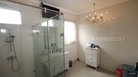 Ada kamar mandi yang cukup luas. Uniknya di sana terdapat televisi yang diletakkan di tengah ruangan. Lalu ada lampu gantung mewah. Ia mengatakan semula ia ingin menambahkan bathtub, tetapi tidak jadi. Foto: Tangkapan Layar YouTube TRANS7 OFFICIAL