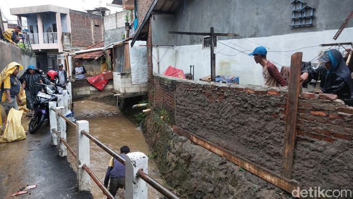 Warga Bandung tengah membersihkan sisa-sisa banjir.