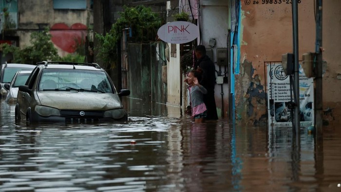 Penampakan Banjir Terjang Rio de Janeiro Brasil People gather next to a firefighters's dinghy on a street after heavy rains in Parque Mambucaba neighbourhood in Angra dos Reis, state of Rio de Janeiro, Brazil April 5, 2025. REUTERS/Aline Massuca