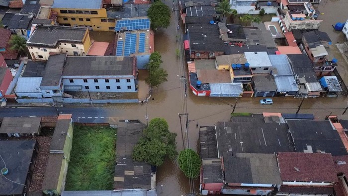Penampakan Banjir Terjang Rio de Janeiro Brasil People gather next to a firefighters's dinghy on a street after heavy rains in Parque Mambucaba neighbourhood in Angra dos Reis, state of Rio de Janeiro, Brazil April 5, 2025. REUTERS/Aline Massuca