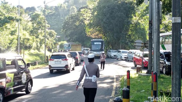 Polisi saat mendorong bus mogok di tikungan Gentong Tasikmalaya.