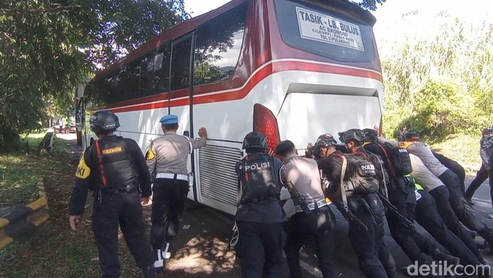 Polisi saat mendorong bus mogok di tikungan Gentong Tasikmalaya.
