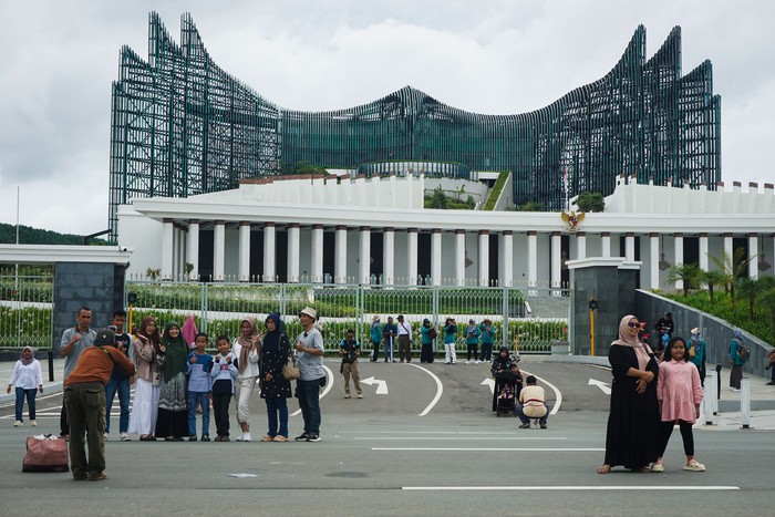 Sejumlah warga mengabadikan momen dengan foto bersama di depan Kompleks Istana Kepresidenan, Ibu Kota Nusantara (IKN), Penajam Paser Utara, Kalimantan Timur, Minggu (6/4/2025).  Menurut Otorita IKN bahwa jumlah kunjungan masyarakat ke IKN itu sejak 27 Maret hingga 5 April lebih dari 64 ribu orang yang berasal dari berbagai daerah di Indonesia maupun mancanegara. ANTARA FOTO/Aditya Nugroho/mrh/nz