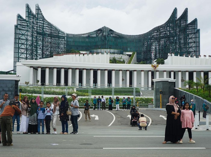 Sejumlah warga mengabadikan momen dengan foto bersama di depan Kompleks Istana Kepresidenan, Ibu Kota Nusantara (IKN), Penajam Paser Utara, Kalimantan Timur, Minggu (6/4/2025).  Menurut Otorita IKN bahwa jumlah kunjungan masyarakat ke IKN itu sejak 27 Maret hingga 5 April lebih dari 64 ribu orang yang berasal dari berbagai daerah di Indonesia maupun mancanegara. ANTARA FOTO/Aditya Nugroho/mrh/nz