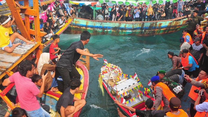 Warga naik perahu saat mengikuti prosesi Pesta Lomban di perairan Pelabuhan Kartini, Jepara, Jawa Tengah, Senin (7/4/2025). Pesta Lomban yang digelar sepekan setelah Idul Fitri dan diikuti ribuan nelayan dengan melarung sesaji berupa kepala kerbau serta hasil bumi ke tengah laut itu sebagai bentuk syukur dan harapan para nelayan kepada Tuhan atas rezeki tangkapan ikan yang melimpah serta keselamatan saat melaut. ANTARA FOTO/Yusuf Nugroho/tom.