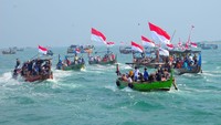 Warga naik perahu saat mengikuti prosesi Pesta Lomban di perairan Pelabuhan Kartini, Jepara, Jawa Tengah, Senin (7/4/2025).