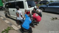 Mobil yang berada di tengah jalan lantas digotong bersama-sama warga dan pengendara yang melintas untuk dipindahkan ke bahu jalan.