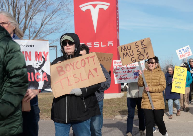 Demonstrators protest against Elon Musk in front of a Tesla dealership in Ann Arbor, Michigan, U.S., March 21, 2025.     REUTERS/Rebecca Cook
