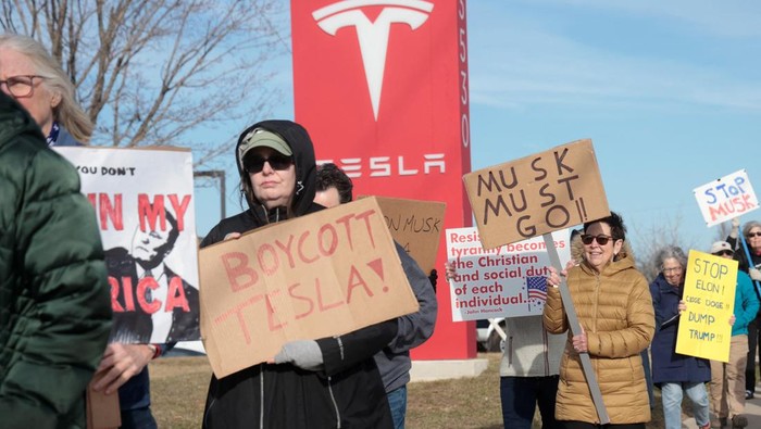 Demonstrators protest against Elon Musk in front of a Tesla dealership in Ann Arbor, Michigan, U.S., March 21, 2025. REUTERS/Rebecca Cook