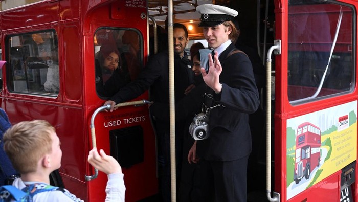 A young boy gestures at a vintage red bus, as vintage red buses give free rides through the heart of the city in London, Britain, March 29, 2025.  REUTERS/Jaimi Joy