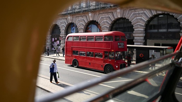 A young boy gestures at a vintage red bus, as vintage red buses give free rides through the heart of the city in London, Britain, March 29, 2025.  REUTERS/Jaimi Joy