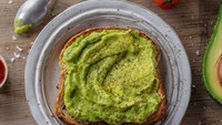 Avocado toast atau roti panggang alpukat menjadi kreasi hidangan alpukat yang populer di dunia. Populer di Amerika Serikat dan Australia. Roti panggang diberi topping irisan alpukat bersama potongan tomat, telur, dan lainnya. Foto: Getty Images/iStockphoto