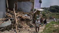 Seorang warga melintas di depan rumah yang rusak akibat pergerakan tanah di Kampung Babut Tengah, Cibabat, Kota Cimahi, Jawa Barat, Selasa (8/4/2025).