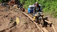 Para tukang ojek harus melewati jalan yang licin untuk menuju ke Kecamatan Seko, Kabupaten Luwu Utara, Sulawesi Selatan.