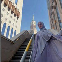 Pesinetron Cinta Fitri tampak berfoto di sebuah tangga tak jauh dari Masjidil Haram. Tissa mengenakan dress warna lilac dipadu dengan hijab segiempat instan. Foto: Dok. Instagram @tissabiani.