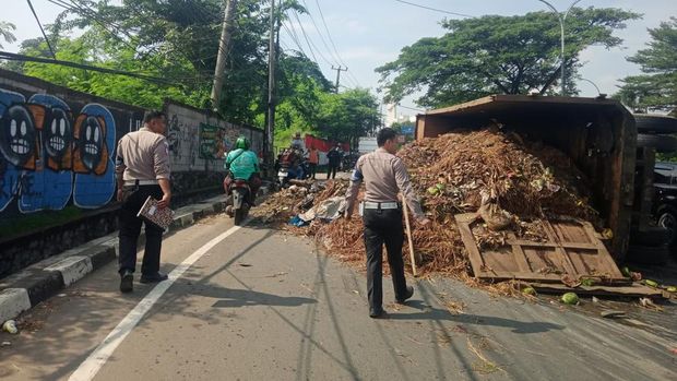 Truk bermuatan sampah terguling di Jalan Raya Transyogi, Cileungsi, Bogor, Jawa Barat, Selasa (8/4/2025) pagi.