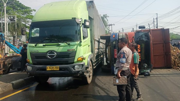 Truk bermuatan sampah terguling di Jalan Raya Transyogi, Cileungsi, Bogor, Jawa Barat, Selasa (8/4/2025) pagi.