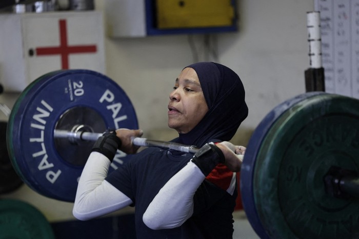 French weightlifting champion Sylvie Eberena trains in Mantes-la-Jolie wearing a hijab, on the outskirts of Paris, on March 26, 2025. Last year, at the age of 43, the French athlete of Muslim faith became amateur national champion in her category, to the great pride of her four children. Now she fears she will no longer be able to compete, as a bill banning religious symbols, including the Islamic veil, in sport will be examined by the National Assembly, after being approved by the Senate in February. (Photo by STEPHANE DE SAKUTIN / AFP)