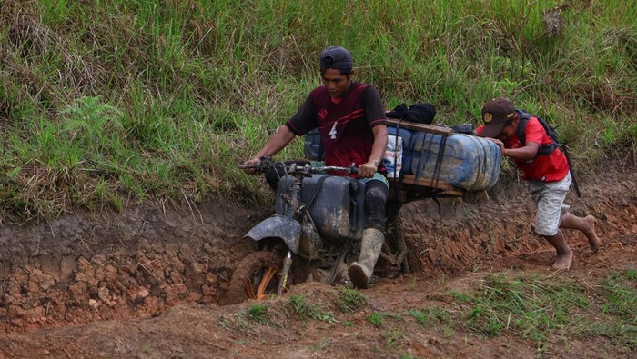 Pengemudi ojek memperbaiki sepeda motornya yang mengangkut jeriken berisi bahan bakar minyak (BBM) di Desa Embonatana, Kecamatan Seko, Kabupaten Luwu Utara, Sulawesi Selatan, Rabu (9/4/2025). Distribusi BBM ke daerah terpencil tersebut menggunakan jasa ojek dengan tarif Rp100 ribu per jeriken untuk memenuhi kebutuhan warga setempat dengan harga eceran untuk jenis pertalite Rp20 ribu per liter dan solar Rp15 ribu per liter. ANTARA FOTO/Arnas Padda/tom.