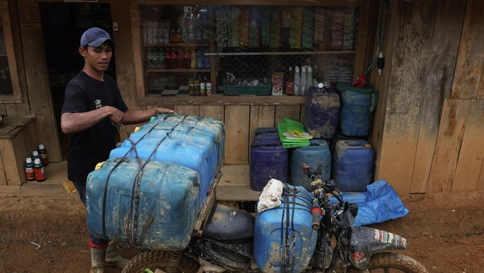 Begini Distribusi BBM ke Daerah Terpencil di Luwu Utara Pengemudi ojek memperbaiki sepeda motornya yang mengangkut jeriken berisi bahan bakar minyak (BBM) di Desa Embonatana, Kecamatan Seko, Kabupaten Luwu Utara, Sulawesi Selatan, Rabu (9/4/2025). Distribusi BBM ke daerah terpencil tersebut menggunakan jasa ojek dengan tarif Rp100 ribu per jeriken untuk memenuhi kebutuhan warga setempat dengan harga eceran untuk jenis pertalite Rp20 ribu per liter dan solar Rp15 ribu per liter. ANTARA FOTO/Arnas Padda/tom.