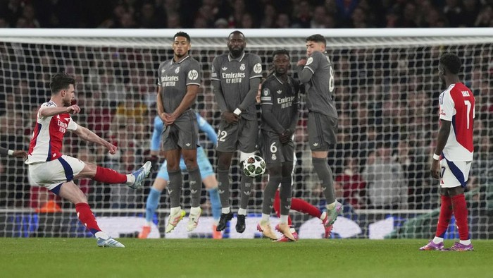 Arsenals Declan Rice, left, scores his sides opening goal during the Champions League quarterfinal first leg soccer match between Arsenal and Real Madrid at the Emirates Stadium in London, Tuesday, April 8, 2025. (AP Photo/Frank Augstein)