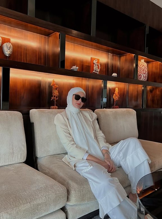 Masih mengenakan hijab instan putih, kali ini Paula tampil edgy. Ia memadukan blazer beige dengan setelan atasan dan celana serba putih. Ia juga menamakai jam tangan dan kaca mata hitam.  Foto: Dok. Instagram @paula_verhoeven.