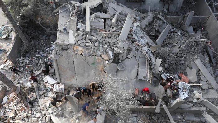 A Palestinian man sits amid rubble at the site of an Israeli strike on a house, in Deir Al-Balah in the central Gaza Strip April 7, 2025. REUTERS/Ramadan Abed     TPX IMAGES OF THE DAY