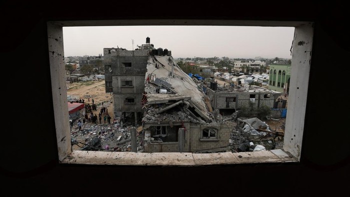 A Palestinian man sits amid rubble at the site of an Israeli strike on a house, in Deir Al-Balah in the central Gaza Strip April 7, 2025. REUTERS/Ramadan Abed     TPX IMAGES OF THE DAY
