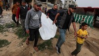 Warga mengevakuasi korban tewas akibat serangan udara Israel.  