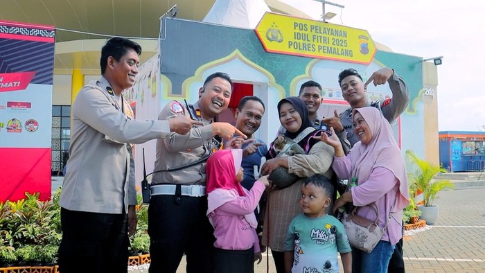 Kasat Lantas Polres Pemalang AKP Arief Wiranto mengamankan kucing milik pemudik di Pos Pelayanan Operasi Ketupat Candi 2025 Rest Area 319B Pemalang, Selasa (8/4/2025).