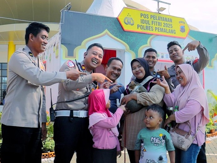 Kasat Lantas Polres Pemalang AKP Arief Wiranto mengamankan kucing milik pemudik di Pos Pelayanan Operasi Ketupat Candi 2025 Rest Area 319B Pemalang, Selasa (8/4/2025).